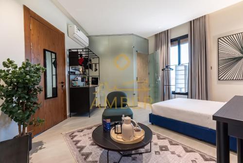 una camera da letto con un letto e un tavolo in una stanza di Amber Hospitality - Qurtubah a Riyad