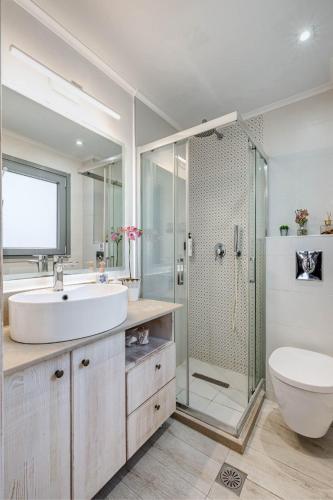 a bathroom with a sink and a shower and a toilet at Seaview stone apartment in Ipsos Beach in Ipsos