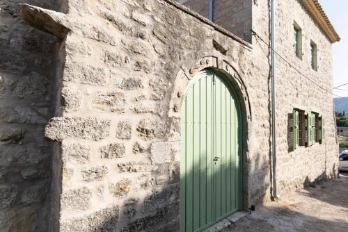 a green door on the side of a stone building at Dervisia Stonehouse 3 in Lazaráta