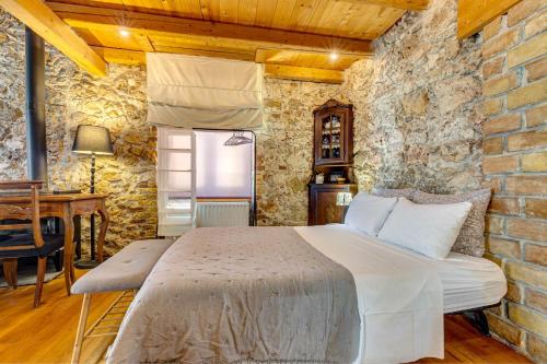 a bedroom with a bed and a brick wall at Seaview stone apartment in Ipsos Beach in Ipsos