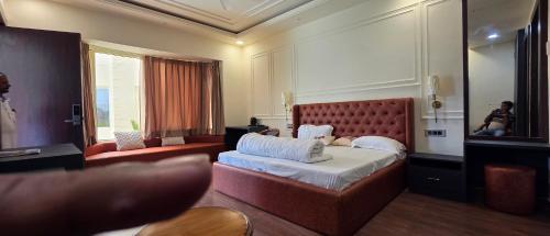 a hotel room with a bed and a mirror at Parinay Pavilion LLP in Bahraich