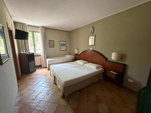 a hotel room with two beds and a window at Hotel Le Mura in Foligno