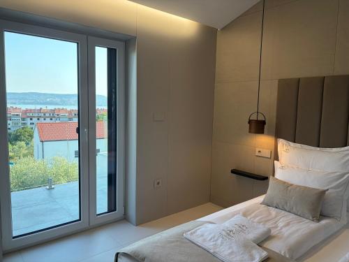 a bedroom with a bed and a large window at Vista on the sea in Ankaran