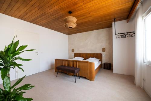 a bedroom with a bed and a wooden ceiling at La Casa Demi in Hetzerath