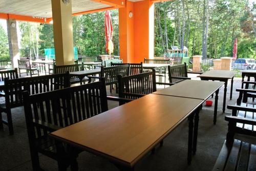 an empty restaurant with wooden tables and chairs at Chatová Osada Pohádka in Vazačka