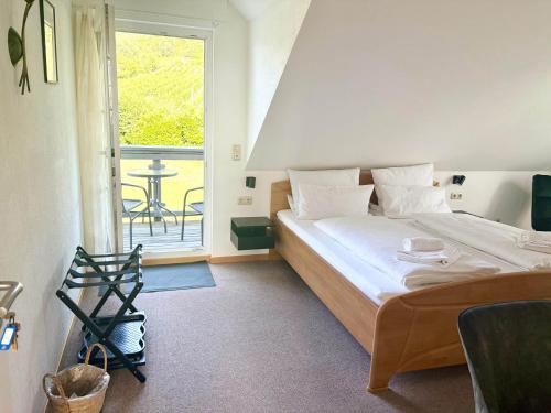 a bedroom with a bed and a window with a table at Gästehaus Helbighof in Neustadt an der Weinstraße