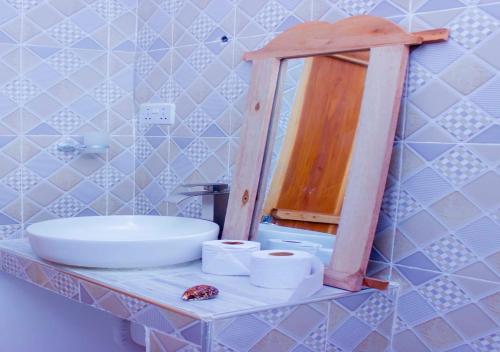 a bathroom with a sink and a mirror on a counter at Datch Hideaway in Kiwengwa