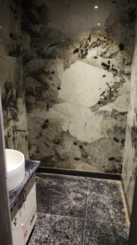 a bathroom with a sink and a stone wall at Hotel bindu in Ghāzīpur