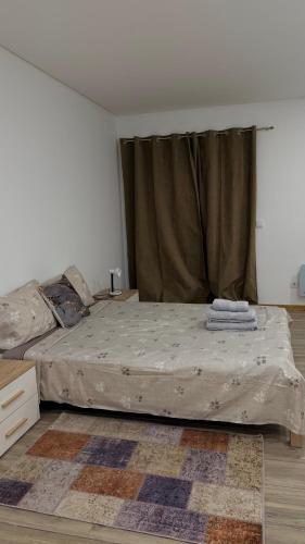 a bedroom with a large bed with a curtain at Quarto privado com banheiro no centro de Viseu in Viseu
