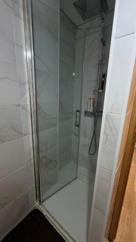 a shower with a glass door in a bathroom at Quarto privado com banheiro no centro de Viseu in Viseu