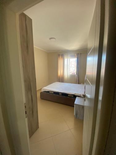 a bedroom with a bed in a room with a window at ApartamentAbiBank in Elbasan