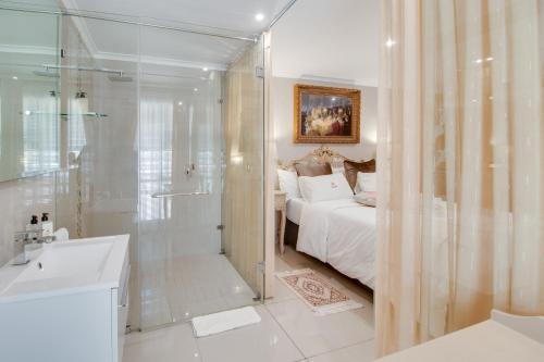 a bathroom with a shower and a bedroom with a bed at Ridgeworth Boutique Guesthouse in Bellville