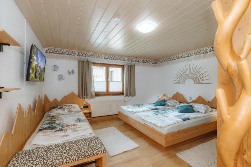 a bedroom with two beds and a window at Almhütten Sonnblick & Almfried in Sonnenalpe Nassfeld