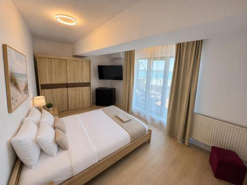 a bedroom with a large bed and a large window at Sea Gem Mamaia - 200m to Beach, XL Terrace, and Beautiful Views in Mamaia