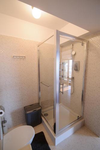 a bathroom with a shower with a toilet and a sink at Sea Gem Mamaia - 200m to Beach, XL Terrace, and Beautiful Views in Mamaia