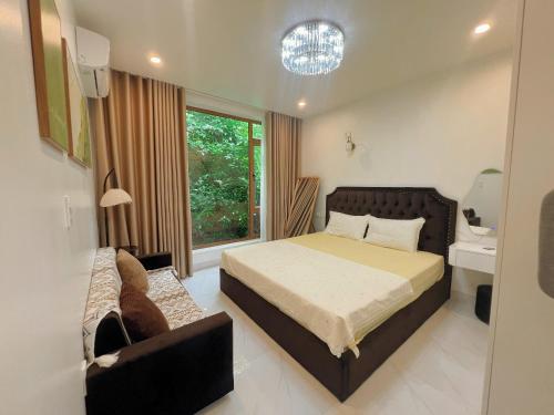 a bedroom with a bed and a chair and a window at ROSE HOUSE Cat Ba island in Cat Ba