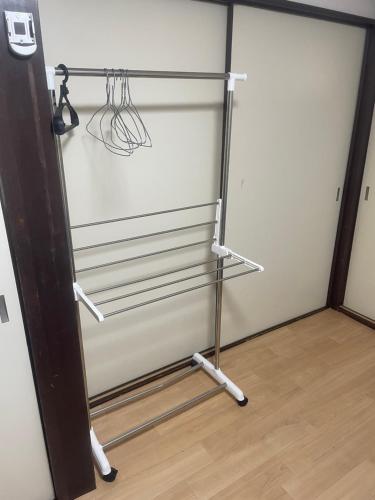 a closet with a refrigerator with hangers on it at 大阪魔力民泊·岸里 in Osaka