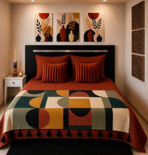 a bedroom with a bed with a colorful quilt at La Dune Bohème chic in Saint-Maurice-de-Beynost