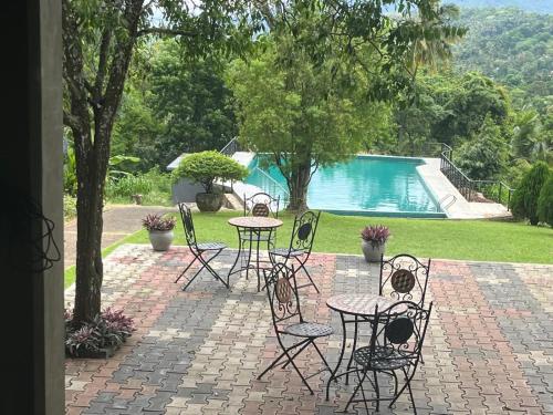 a patio with tables and chairs next to a pool at Kalan Digana in Digana