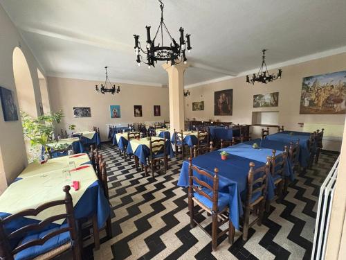 a restaurant with blue tables and chairs and a chandelier at Govinda in Pontinvrea