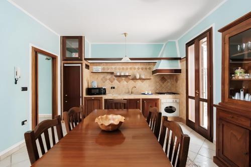 a kitchen with a long wooden table and chairs at Villa Nicole Vista Mare in Andrano