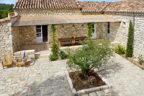 a stone house with a table and chairs in a courtyard at Maison Forte in Montcuq