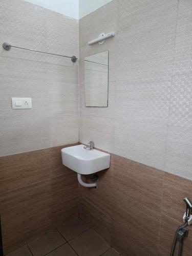 a bathroom with a sink and a mirror at Barza Inn in Kakkanad
