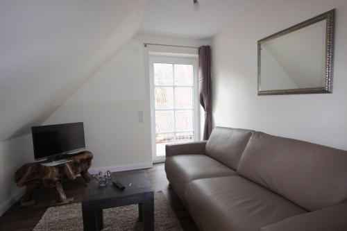 a living room with a couch and a television at Noor-OG-mit-Studio-Nr-4 in Haby