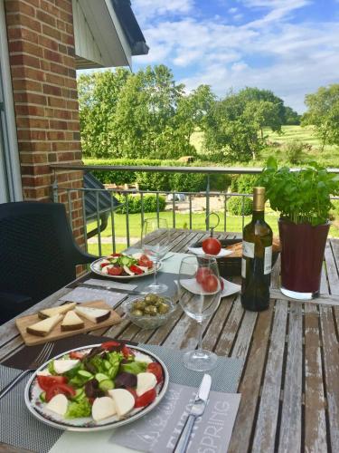 a table with plates of food and a bottle of wine at Noor-OG-mit-Studio-Nr-4 in Haby