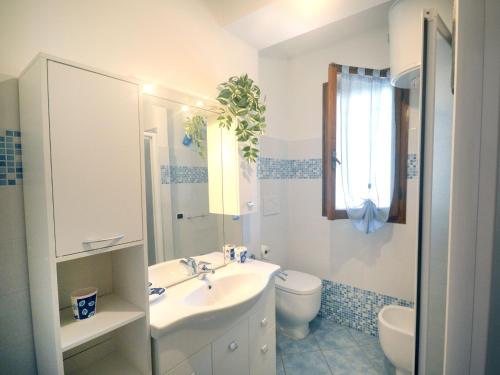 a white bathroom with a sink and a toilet at SIT Holiday Homes in Lido delle Nazioni