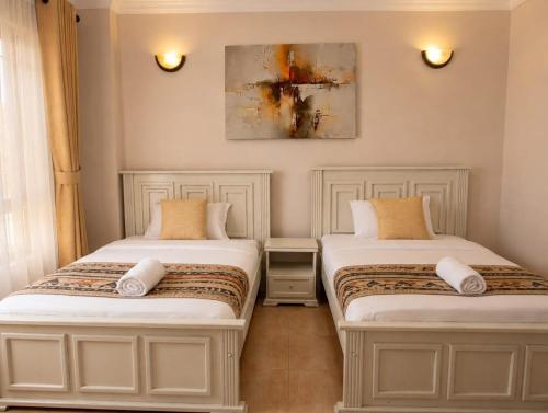 two beds sitting next to each other in a room at Lakeview 3BR Apartment Nakuru CBD in Nakuru