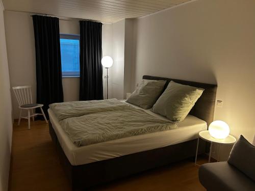 a bedroom with a bed and a window and a chair at Wohnung mit Terrasse in Hirschaid