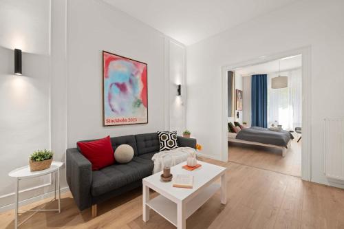 a living room with a couch and a table at Chic 2BR Loft Steps from Great Synagogue Budapest in Budapest