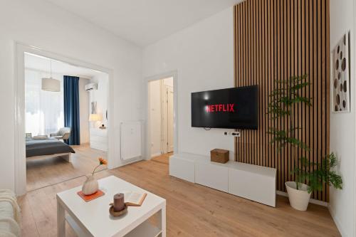 a living room with a tv on a wall at Chic 2BR Loft Steps from Great Synagogue Budapest in Budapest