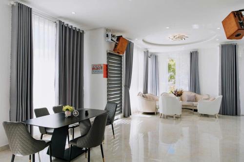 a living room with a table and chairs and a couch at villa Trung Nghĩa 5 in Da Lat