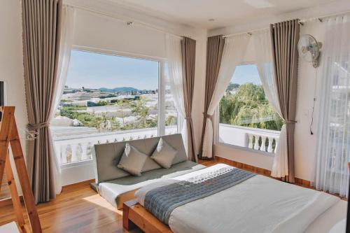 a bedroom with a bed and a large window at villa Trung Nghĩa 5 in Da Lat
