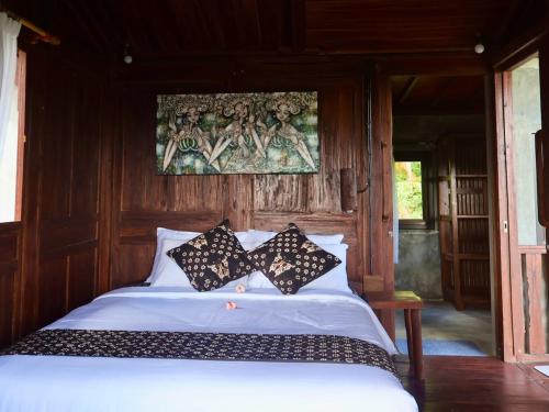 a bed with two black and white pillows on it at Villa Hola Agung in Karangasem