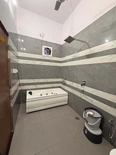 a bathroom with a tub and a toilet in it at MShotel Surajgarh in Sūrajgarh