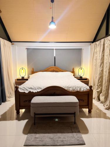 a bedroom with a bed and two lamps on two tables at Alit House in Phra Nakhon Si Ayutthaya