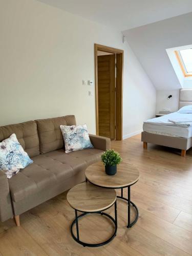 a living room with a couch and a table and a bed at Widokówka Radostowa in Podmąchocice
