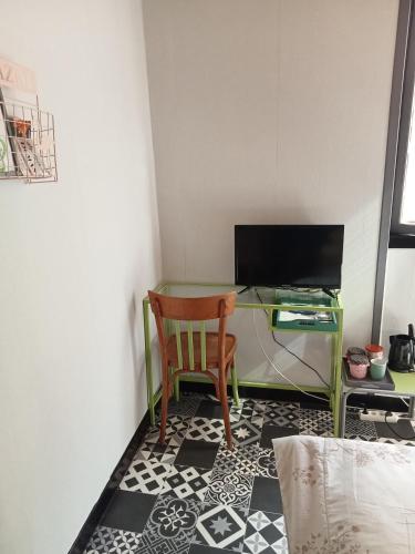 a desk with a chair and a desk with a computer at Le repaire des écureuils in Bourg-Argental