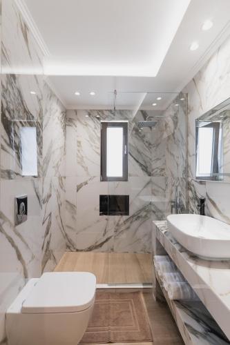 a bathroom with a toilet and a sink at Athena Villas in Vasilikos