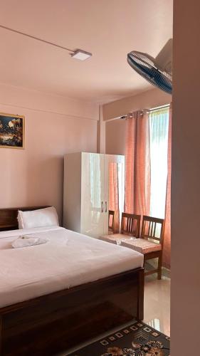 a bedroom with a bed and a chair and windows at Serenity View Stay in Shillong
