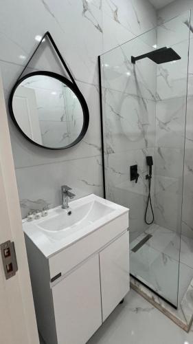 a bathroom with a sink and a mirror and a shower at 21 floor apartment in Tbilisi City