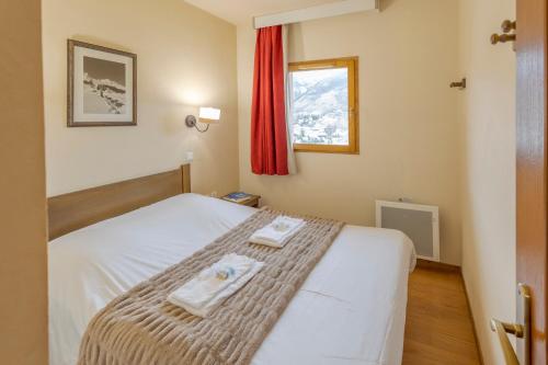 a bedroom with a bed with two towels on it at Résidence Goélia Les Chalets Valoria in Valloire