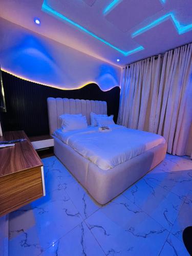 a bedroom with a large bed with blue lights at Flexxy Apartment Hotel in Oshogbo