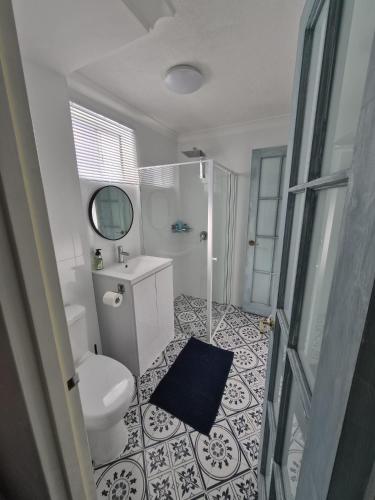 a bathroom with a toilet and a sink and a mirror at Avocet Apartment in Perth