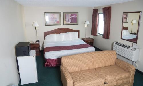 a hotel room with a bed and a chair at Americas Best Value Inn St. Louis / South in Saint Louis