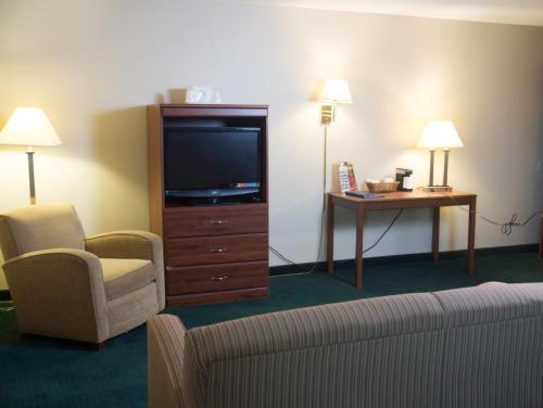 a hotel room with a couch and a tv and a chair at Americas Best Value Inn St. Louis / South in Saint Louis