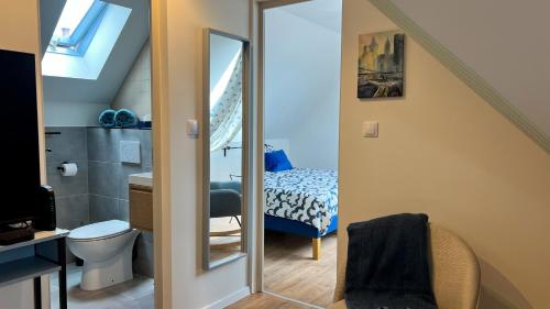a bathroom with a bed and a toilet and a mirror at Hello Apartman in Budaörs